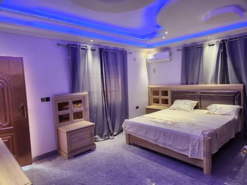 弗里敦Medi Square Lodge的一间卧室设有一张蓝色天花板的大床