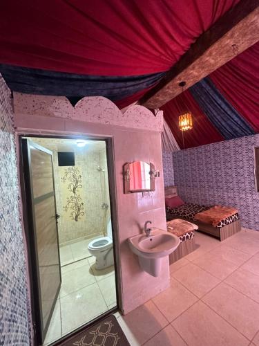 瓦迪拉姆Dream Bedouin life camp的粉红色的浴室设有卫生间和水槽