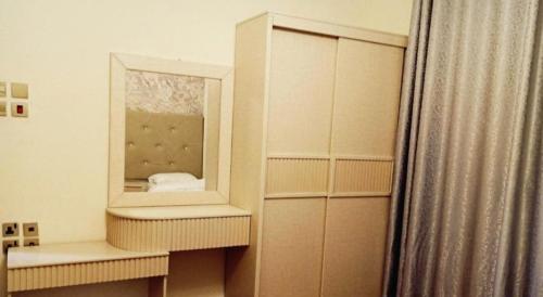 麦地那Al Asar almasi Suite Apartments的更衣室配有镜子和窗帘