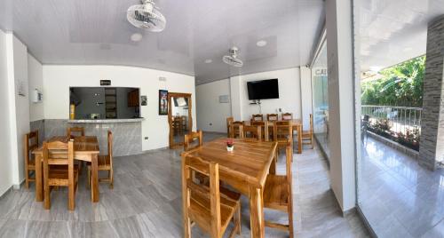 卡普兰干HOSTAL LAS FLORES的用餐室配有木桌和椅子