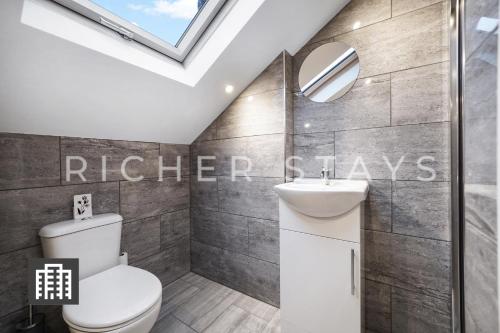 伦敦Hackney Suites - En-suite rooms & amenities的浴室配有卫生间、水槽和天窗。