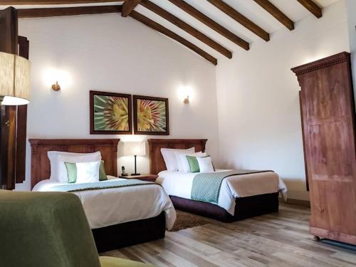 贾丁Casa Passiflora Hotel Boutique的酒店客房,设有两张床和一张沙发