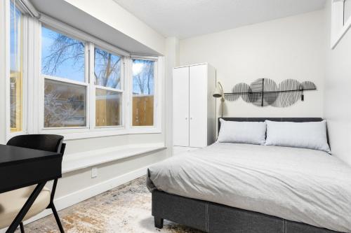 渥太华14 minutes from downtown, brand new home in Ottawa的卧室配有一张床、一张书桌和窗户。