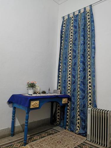 突尼斯Dar mima baya的散热器旁的蓝色窗帘蓝色桌子