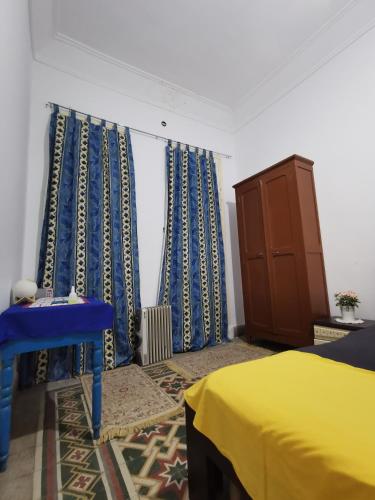 突尼斯Dar mima baya的一间卧室配有蓝色和黄色的窗帘和床