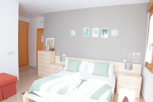 锡古恩萨Hostal-Casa Rural Rosa-Nonna的一间卧室配有带白色床单和绿色枕头的床。