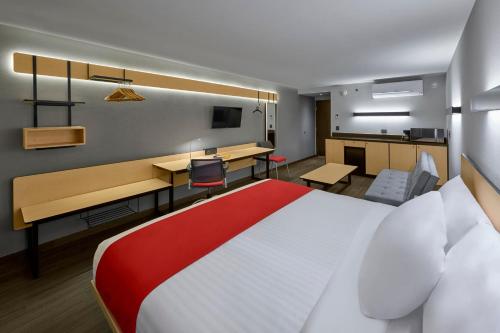 维多利亚城维多利亚城城市快捷酒店的酒店客房设有一张大床和一张书桌。