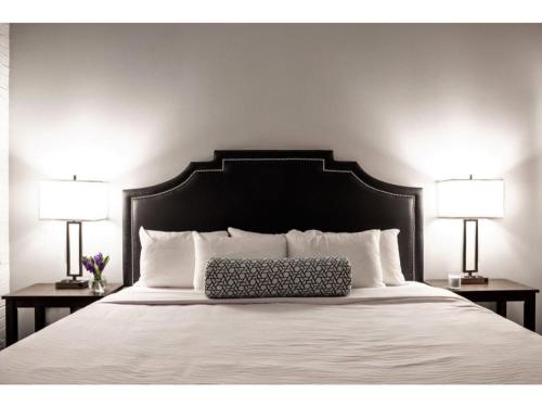 印第安纳波利斯Modern Apartment Close To Everything CozySuites的一张带黑色床头板和两盏灯的床