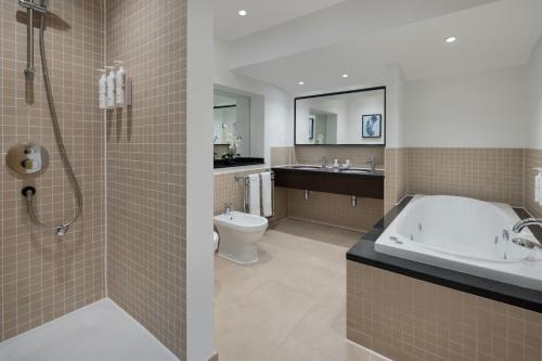 彼得伯勒Delta Hotels by Marriott Peterborough的带浴缸、卫生间和盥洗盆的浴室
