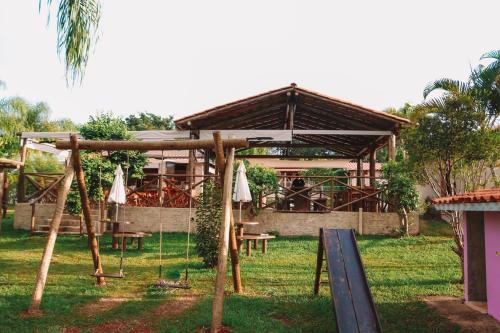 瓜佩Pousada Estância Mineira的庭院中带桌子和遮阳伞的凉亭
