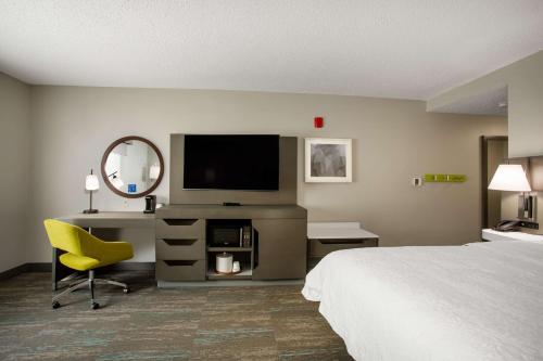 埃尔金斯埃尔金斯希尔顿恒庭酒店的酒店客房配有一张床、一张书桌和一台电视。