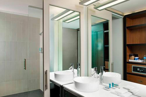 比奇伍德比奇伍德雅乐轩酒店的一间带两个盥洗盆和大镜子的浴室