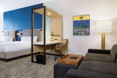 托皮卡SpringHill Suites by Marriott Topeka Southwest的配有一张床和一张书桌的酒店客房