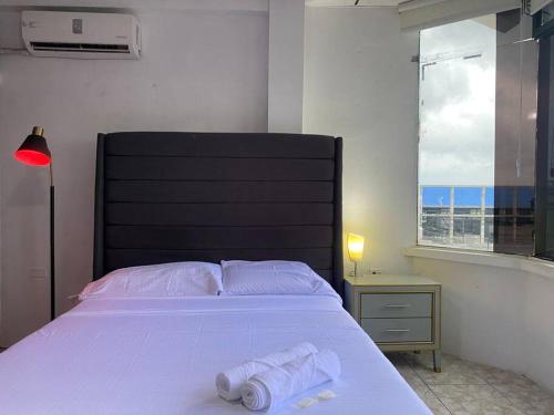 马查拉Moderno, grande, amplia vista, parqueo的一间卧室配有一张床,上面有两条毛巾