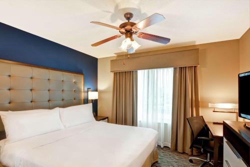 休斯顿休斯顿宁静商业街惠庭套房酒店的酒店客房配有一张床和吊扇。