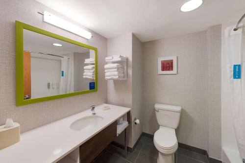 南乌特纳纽埃特希尔顿恒庭酒店的一间带卫生间、水槽和镜子的浴室