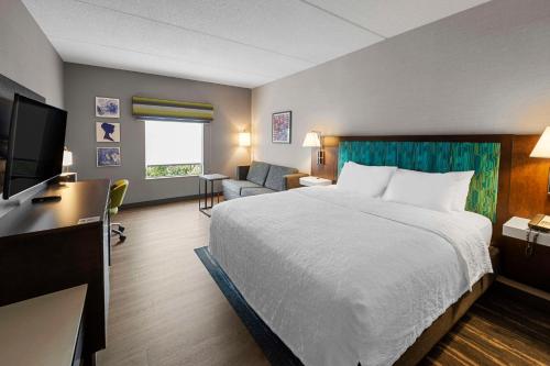 南乌特纳纽埃特希尔顿恒庭酒店的酒店客房,配有床和电视