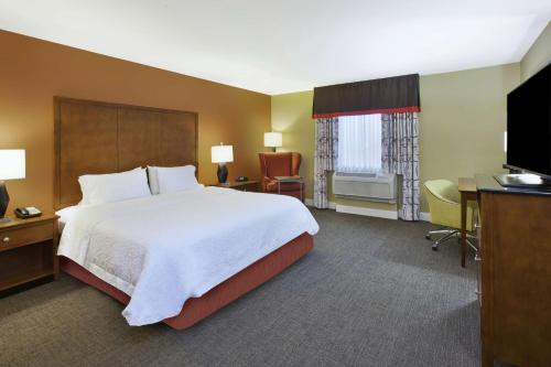 威奇托东北威奇托汉普顿住宿及套房酒店的酒店客房配有一张床、一张书桌和一台电视。