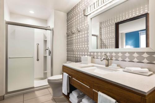 皇后区长岛市/曼哈顿景观家庭2套房酒店的一间带卫生间、水槽和镜子的浴室