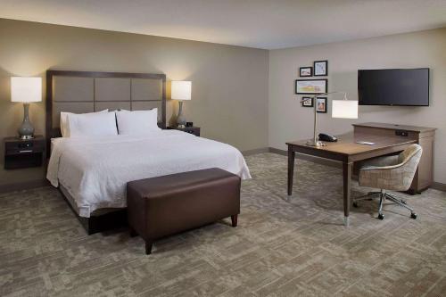 加登城Hampton Inn by Hilton Garden City Long Island的酒店客房配有一张床、一张书桌和一台电脑