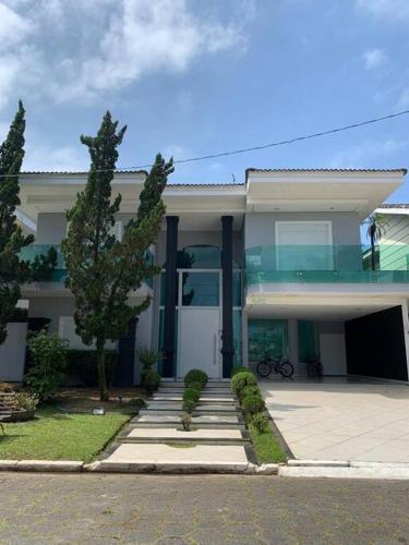 瓜鲁雅Casa em Guarujá-Jardim Acapulco的前面有楼梯的大型白色房屋