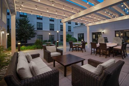 Carle PlaceHomewood Suites by Hilton Carle Place - Garden City, NY的天井配有沙发、椅子和桌子