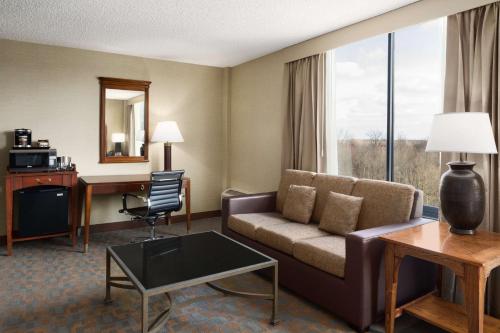 萨默塞特萨默塞特希尔顿逸林酒店及行政会议中心的酒店客房设有沙发、桌子和书桌