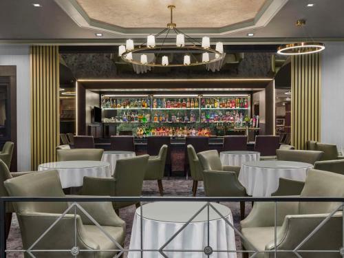 利堡李堡/乔治·华盛顿大桥希尔顿逸林酒店的一间带桌椅的餐厅和一间酒吧