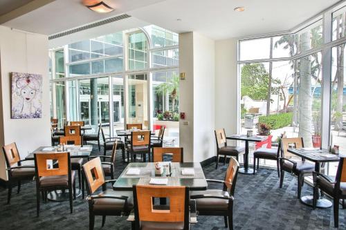 劳德代尔堡GALLERY One - A DoubleTree Suites by Hilton Hotel的餐厅设有桌椅和窗户。
