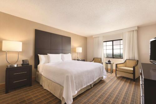 格林维尔格林维尔高尔夫及会议中心大使套房度假酒店的酒店客房设有一张大床和一台电视。