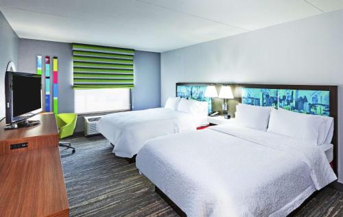 休斯顿乔治·布什洲际机场汉普顿套房酒店的酒店客房设有两张床和一台平面电视。