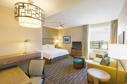 休斯顿休斯顿市中心希尔顿惠庭套房酒店的酒店客房带一张床、一张桌子和椅子