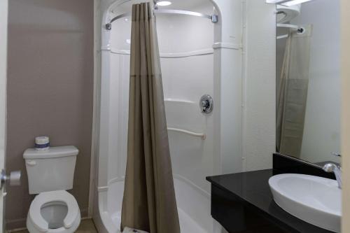 拉夫金Motel 6-Lufkin, TX的带淋浴、卫生间和盥洗盆的浴室