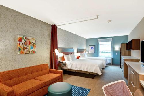 拉波特Home2 Suites by Hilton La Porte的酒店客房,配有床和沙发
