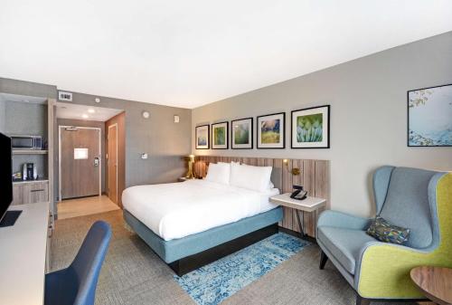 休斯顿Hilton Garden Inn Houston Hobby Airport的配有一张床和一把椅子的酒店客房