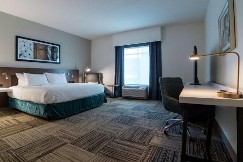 斯帕坦堡Hilton Garden Inn Spartanburg的配有一张床和一张书桌的酒店客房