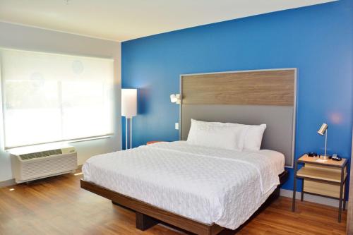 大章克申Tru By Hilton Grand Junction Downtown的一间卧室设有一张蓝色墙壁的大床