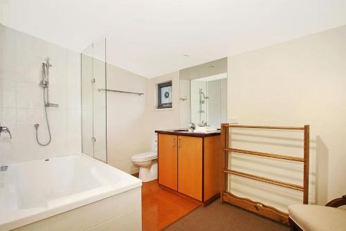 布赖特Bright Woodlands Retreat的带浴缸、淋浴和卫生间的浴室