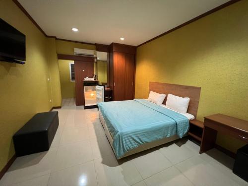 乌隆他尼จินตคามโฮมเพลส/Jintakam Home Place的一间卧室配有一张床和一台电视