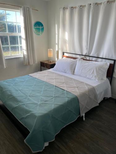 大特克岛John’s Place的一间卧室配有一张带蓝色毯子的大床