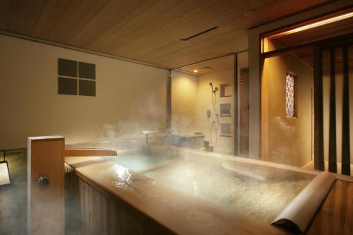 箱根强罗花坛传统日式旅馆的浴室里装满蒸汽的浴缸