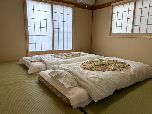 富士吉田市Guest House Fuji no Yado Akebono Building A - Vacation STAY 74316v的一间房间里设有三张床,上面有两块比萨饼