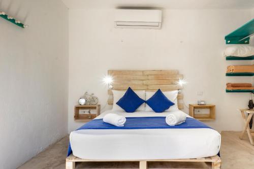 图卢姆Casa Toloc Tulum的一间卧室配有一张带蓝色枕头的大床