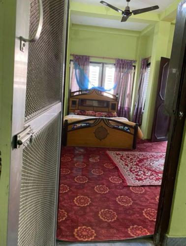巴拉特布尔pujan's homestay的一间卧室设有床、窗户和门
