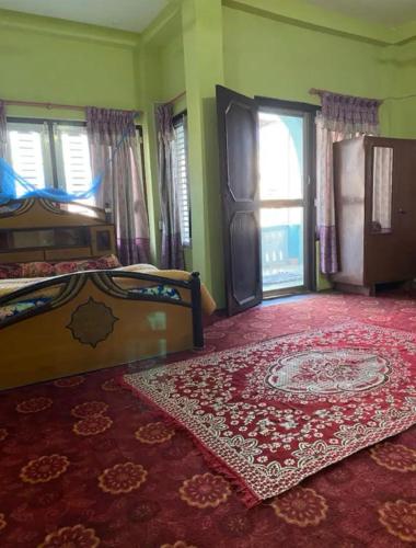 巴拉特布尔pujan's homestay的一间卧室配有两张床,铺有红地毯