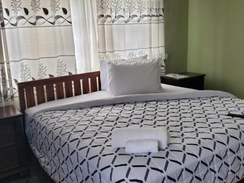 塔科拉迪Casa Consuelo Guest House的一间卧室配有一张大床和两条毛巾