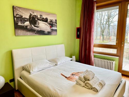 菲亚诺Natura e Golf con giardino privato的卧室配有一张白色的床,并有一张汽车的照片