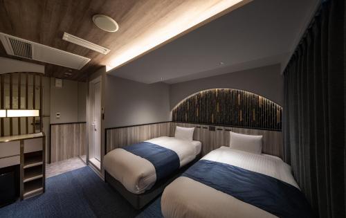 大阪道顿堀酒店的酒店客房设有两张床和电视。