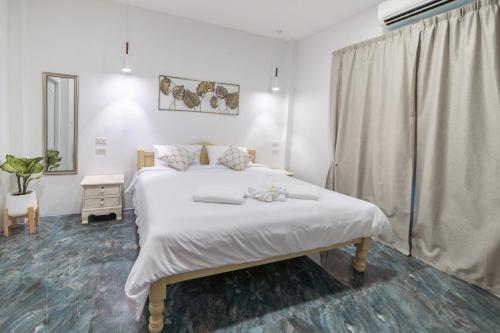Haad Chao PhaoApple Villas的卧室设有一张白色大床和一扇窗户。