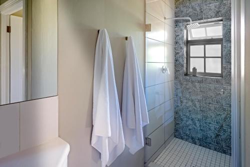 克尼斯纳Belvidere Manor Lagoonside Cottages的带淋浴和白色毛巾的浴室